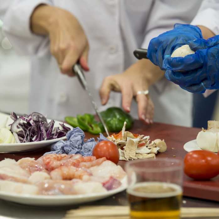 Fotografía de cocineros cortando comida